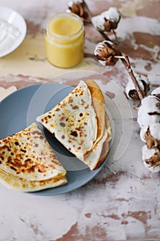 Stack of delicious homemade pancakes on plate with honey, sour cream and tea. Breakfast. Rustic style, close up top view. Flat lay