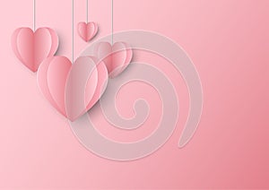 Cute pastel paper hearts hang on top on pink background