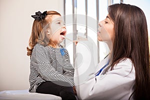Cute pediatrician examining girl