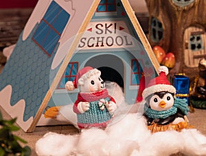 Cute penguin and polar bear mini figures are posing infront of a ski chalet