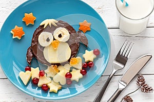Cute penguin shaped chocolate spread sandwich with fresh fruit for kids