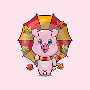 Cute pig with umbrella at autumn season.