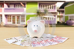 Cute piggy bank on a stack of cash. Concept of savings and money