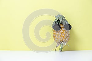 A cute pineapple wearing sunglasses on yellow paper
