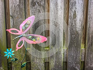 Cute pink butterfly garden decoration with palisade background