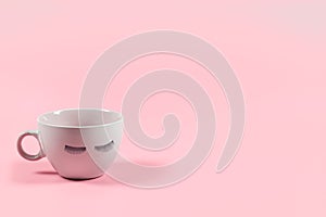 Cute pink coffee or tea mug with false lashes on a pink background with copy space.