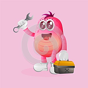 Cute pink monster holding spanner and tolls box