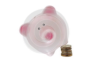 Cute pink piggy bank standing on a tilt position with one leg on