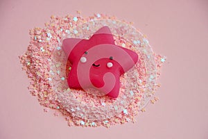 Cute pink star lying in pink glitters. Nursery concept photo