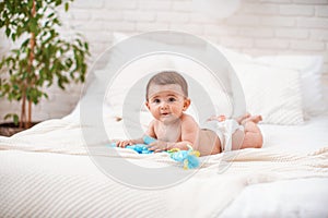 Cute plump baby of 4 months lies on his stomach and looks away