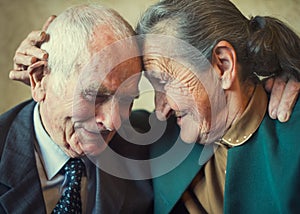 Cute 80 plus year old married couple posing for a portrait in their house. Love forever concept photo