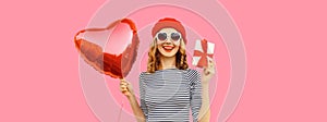 Cute portrait of happy smiling woman with red heart shaped balloon and gift box