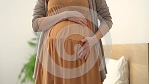 A cute pregnant woman dancing. Cheerful pregnancy and positive attitude.