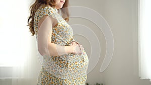 Cute pregnant woman dansing. Cheerful pregnancy and positive attitude.