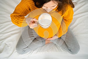 Cute pregnant woman holds in hand a cup of coffee. Concept of a happy pregnancy. Not healthy drinks