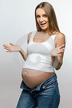 Cute pregnant woman in jeans looking happy and excited