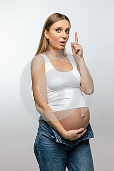 Cute pregnant woman in jeans looking happy and excited