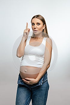 Cute pregnant woman in jeans looking happy and excited