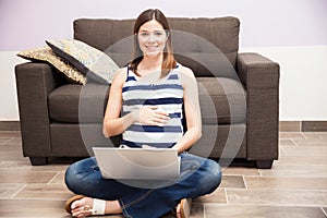 Cute pregnant woman working at home