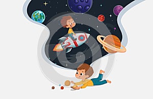 Cute preschool boy sit on the floor and play with the toy planets and imagine himself trevel on the rocket. Space