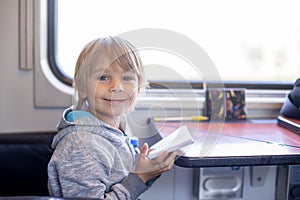 Cute preschool child with backpack, running for the train on a trainstation photo