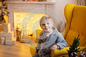 Cute preschool child, blond boy with pet dog, playing in decorated Christmas room