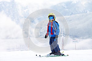 Cute preschool child, boy, skiing happily in Austrian ski resort