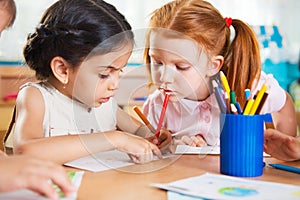 Cute preschoolers drawing with colorful pencils