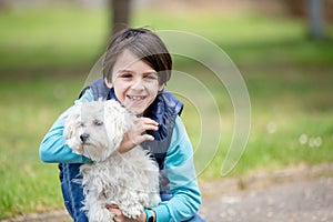 Cute preteen boy, hugging his pet dog  in the park