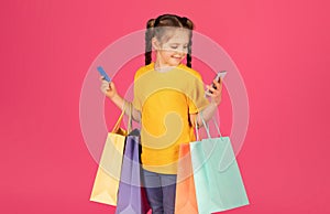 Cute Preteen Girl Holding Credit Card And Shopping Bags And Using Smartphone