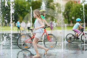 Cute preteen girl playing in fountains on newly renovated Lukiskes Square in Vilnius, Lithuania. Child having fun with water on