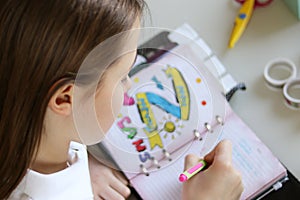 Cute preteen little girl writing her dreams in diary.