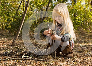 Cute pretty little girl building a wigwam