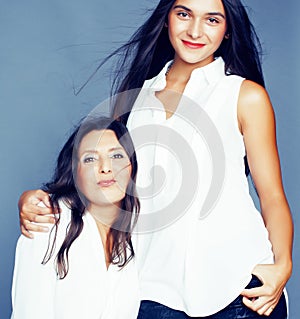 Cute pretty teen daughter with mature mother hugging, fashion style brunette, lifestyle people concept