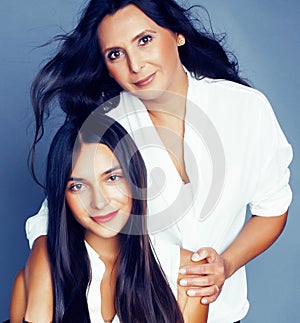 Cute pretty teen daughter with mature mother hugging, fashion style brunette, lifestyle people concept