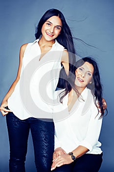 Cute pretty teen daughter with mature mother hugging, fashion style brunette, lifestyle people concept close up