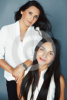 Cute pretty teen daughter with mature mother hugging, fashion style brunette, lifestyle people concept close up