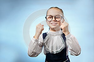 Cute Primary Schoolgirl Make Fist Blue Background