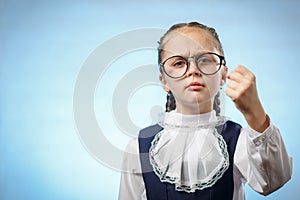 Cute Primary Schoolgirl Make Fist Blue Background