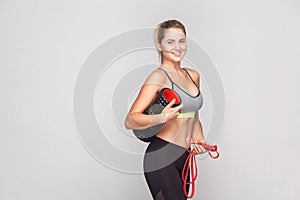 Cute professional instructor holding foam roller and ready to ma