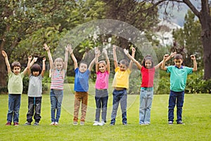 Cute pupils cheering on the grass outside