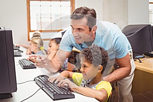 Cute pupils in computer class with teacher