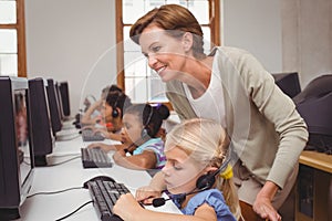 Cute pupils in computer class with teacher