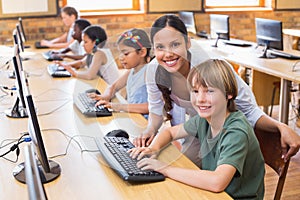 Cute pupils in computer class with teacher