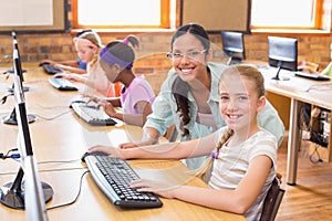 Cute pupils in computer class with teacher