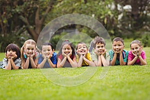 Cute pupils lying on the grass outside