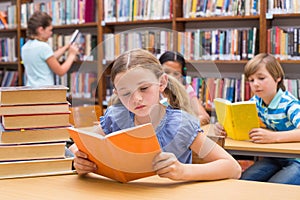 Cute pupils reading in library