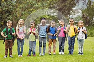 Cute pupils with schoolbags outside