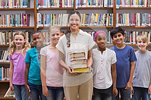 Cute pupils and teacher having class in library