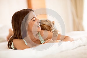 Cute puppy sniff girl in bed photo